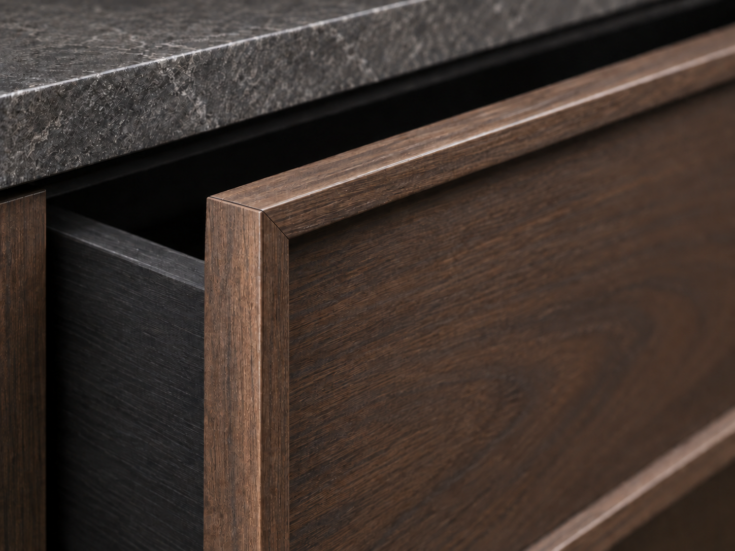 Angled close-up of a raised walnut drawer edge and corner joint surrounding a recessed veneer panel